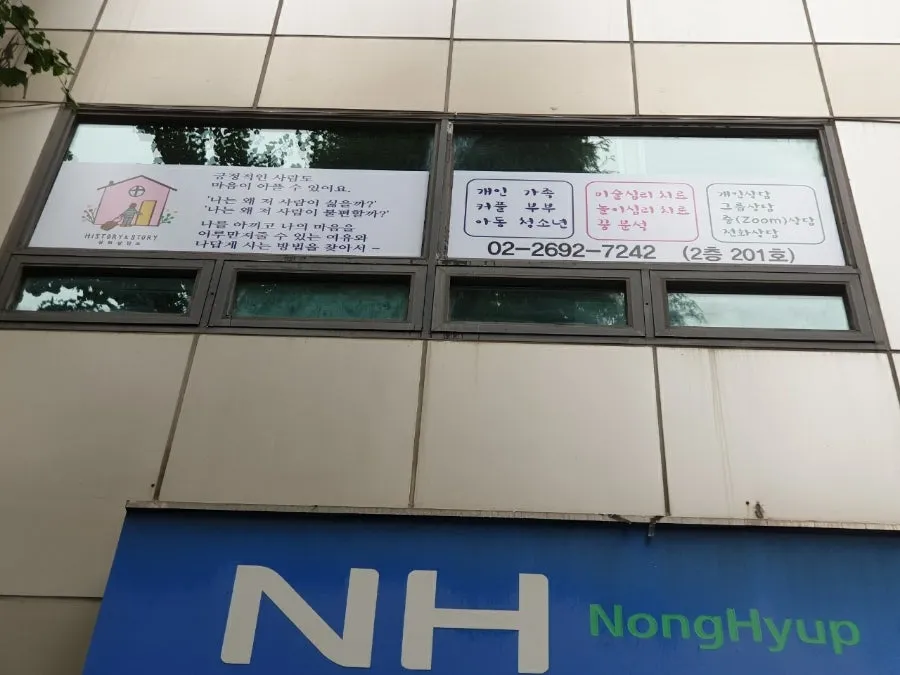 1층 농협 간판 위 2층 창문에 붙은 상담소 안내판